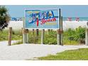 Sign showing Siesta Beach, with sand, sky and people in the background at 5416 Swift Rd # 27, Sarasota, FL 34231