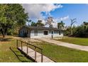 Inviting single-story home with a long driveway and a lush green lawn at 6329 David Blvd, Port Charlotte, FL 33981