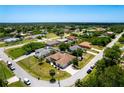 Wide aerial shot of the house in a residential neighborhood with green trees and blue skies at 8315 Raoul Ave, North Port, FL 34291
