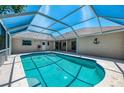 Inviting screened-in pool area with a bright blue pool and ample space for relaxation and entertainment at 452 Greenwich Nw Ave, Port Charlotte, FL 33952