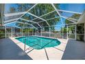 Refreshing screened-in pool with clear blue water and a surrounding patio, perfect for outdoor leisure at 452 Greenwich Nw Ave, Port Charlotte, FL 33952