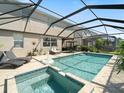 Relaxing screened-in pool with a spa, chaise lounges, and outdoor seating at 11663 Anhinga Ave, Venice, FL 34292