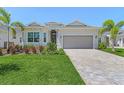 Beautiful single-story home featuring a well-manicured lawn, paved driveway, and a two-car garage at 14413 Heritage Landing Blvd, Punta Gorda, FL 33955