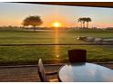 Sunset view from the outdoor patio seating area overlooking the lush golf course at 14413 Heritage Landing Blvd, Punta Gorda, FL 33955