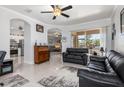 Open-concept living room featuring neutral paint, ceiling fan, and sliding glass doors to the outdoor patio at 16450 Bauers Ave, Port Charlotte, FL 33954