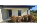 Welcoming front entrance featuring a dark-colored door, and natural colored landscaping at 17374 Gadsen Ave, Port Charlotte, FL 33948