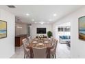 Dining room with view into living room, island bar, tile floors, and modern decor at 182 Dowling Ne Ave, Port Charlotte, FL 33952