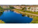 Scenic view of pond with condos in background and rock detail with plants on the side and an aeration fountain in the middle at 19375 Water Oak Dr # 106, Port Charlotte, FL 33948