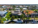 Aerial view of a waterfront home with tile roof, screened in lanai, boat, and dock on the water at 211 Lido Dr, Punta Gorda, FL 33950