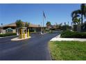 Gated community entrance with stone pillars and an American flag at 24141 Green Heron Dr # 23, Punta Gorda, FL 33980