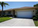 Charming single-story home featuring a well-manicured lawn and an attached two-car garage at 24141 Green Heron Dr # 23, Punta Gorda, FL 33980