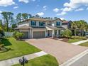 Beautiful two-story home with three-car garage, brick driveway, and well-manicured lawn in a quiet neighborhood at 2427 Carnation Ct, North Port, FL 34289