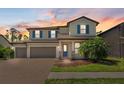 Two-story home with a three-car garage and a colorful sunset background at 2427 Carnation Ct, North Port, FL 34289