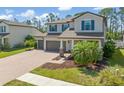 Lovely two-story home showcasing lush landscaping, a three-car garage, and a spacious driveway at 2427 Carnation Ct, North Port, FL 34289