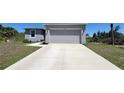 Charming home with a two-car garage, gray paint, and a large concrete driveway at 26456 View Dr, Punta Gorda, FL 33983