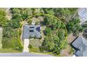 Aerial view of a single-story home in a wooded lot with solar panels, a long driveway, and proximity to neighboring homes at 2666 Barry Rd, North Port, FL 34286