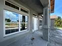New construction home featuring a covered front porch with decorative column and a large window reflecting the beautiful outdoors at 337 Rosario St, Punta Gorda, FL 33983