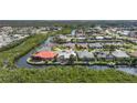 Aerial view of waterfront homes in a neighborhood on a canal with mature trees and tropical landscaping at 3513 Dileuca St, Punta Gorda, FL 33950