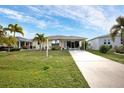 Charming single-story home with well-maintained lawn, palm trees, and a long driveway at 3520 Kenneth Rd, Port Charlotte, FL 33953