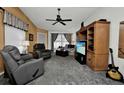 Cozy living room features comfortable seating, a ceiling fan, and entertainment center at 3520 Kenneth Rd, Port Charlotte, FL 33953