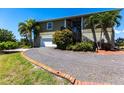 Charming two-story home with a gravel driveway and lush landscaping at 3712 Balboa Ct, Punta Gorda, FL 33983