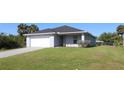 Well-maintained one-story home with a lush green lawn and a paved driveway at 4071 Conestoga St, Port Charlotte, FL 33948
