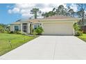 Well-maintained single-story home with an attached two-car garage and concrete driveway, surrounded by lush greenery at 4463 Cromey Rd, North Port, FL 34288