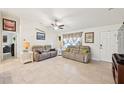 Cozy living room with tile floors, ceiling fan, decorative window treatment, and ample space for relaxation at 4463 Cromey Rd, North Port, FL 34288