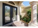 Elegant double door entry with decorative glass and a stone column at 4676 Tuscana Dr, Sarasota, FL 34241