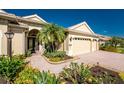 Beautiful front entrance with a brick paved driveway and lush tropical landscaping at 4676 Tuscana Dr, Sarasota, FL 34241
