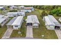 Aerial view of a single-story home featuring a screened porch and a well-manicured lawn at 5488 Holiday Park Blvd, North Port, FL 34287