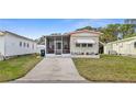 Charming single-story home featuring a screened porch, awning, and well-manicured lawn at 5488 Holiday Park Blvd, North Port, FL 34287
