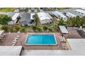 Aerial view of a community pool featuring lounge chairs on a brick patio deck at 5488 Holiday Park Blvd, North Port, FL 34287