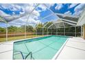 Screened-in pool showcasing clear water and a spacious patio area at 657 Hartford Nw Dr, Port Charlotte, FL 33952