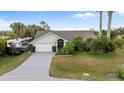 Well-manicured single-story home with RV parking and tropical landscaping at 719 Ellicott Nw Cir, Port Charlotte, FL 33952
