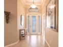 Bright foyer with tile flooring, decorative lighting, display cabinet, and an arched window above the front door at 10227 Windsong Rd, Punta Gorda, FL 33955