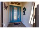 Inviting blue front door with decorative glass panels and elegant hardware, adorned with decorative wall art at 10227 Windsong Rd, Punta Gorda, FL 33955