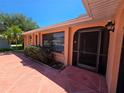 A welcoming covered front entrance with a screen door and a well-kept garden area at 1173 Belkton Ave, Port Charlotte, FL 33948