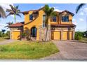 Beautiful two-story house featuring stone accents, a well-manicured lawn, and a three-car garage at 14142 Fort Myers Ave, Port Charlotte, FL 33981