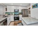 Bright kitchen features stainless steel appliances, white cabinets, and a backsplash at 1701 Beach Rd # 305, Englewood, FL 34223