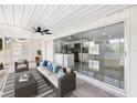 A modern patio with stylish furniture, ceiling fan, and glass sliding doors for indoor-outdoor living at 18263 Ohara Dr, Port Charlotte, FL 33948