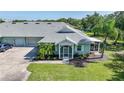 Inviting single-story home with a well-manicured lawn, screened entrance, and attached two-car garage at 2024 Royal Tern Cir, Punta Gorda, FL 33983