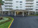 Welcoming entrance to Harbour House building featuring elegant landscaping and covered entry at 2401 Bayshore Blvd # 1204, Tampa, FL 33629