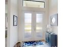 Inviting entryway with frosted glass doors, a blue accent cabinet, and tasteful decor at 24103 Pyramid Way, Punta Gorda, FL 33955