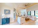 Bright living room featuring white furniture, high ceilings with a fan, and an open floor plan at 24103 Pyramid Way, Punta Gorda, FL 33955