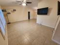 Spacious living room with tile floors, ceiling fan, neutral paint, and television at 243 Harbor Blvd, Port Charlotte, FL 33954
