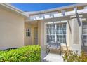 Inviting front patio with decorative pergola, rocking chair, and lush landscaping for relaxed outdoor living at 2508 Magnolia Cir, North Port, FL 34289