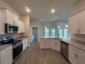 Modern kitchen with stainless steel appliances, granite countertops, and white cabinets at 25156 Rosamond Ct, Punta Gorda, FL 33983
