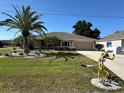 Well-maintained tan house with a lush green lawn, palm trees, and decorative accents, enhancing its curb appeal at 25263 Padre Ln, Punta Gorda, FL 33983