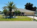 Beautiful tan home with well manicured lawn, lush landscaping and an attached two car garage at 25263 Padre Ln, Punta Gorda, FL 33983
